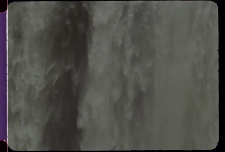 Large waterfall splashes into a body of water below