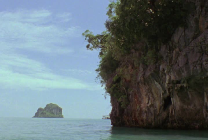 The shore is lined with large rocks covered in green