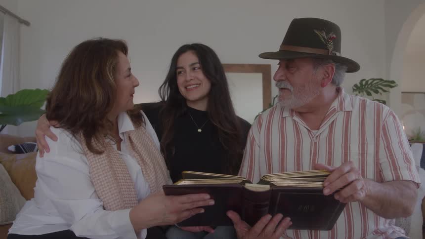 Grandparents smile while looking at their granddaughter