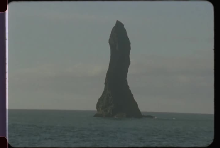 A large rock formation is in the ocean