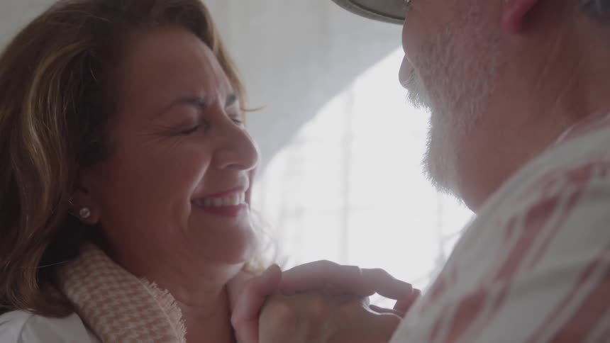 Woman smiling with closed eyes while holding a mans hands