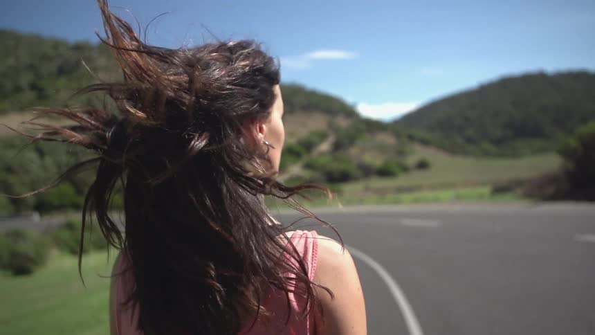 Woman walks alongside a road