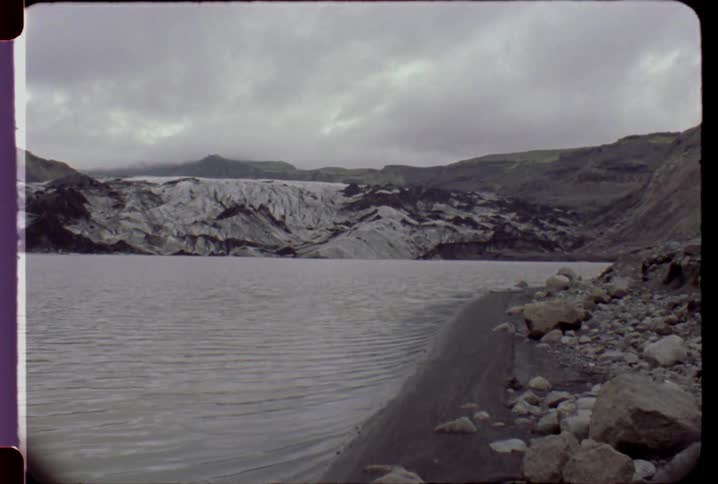 Water laps a shoreline on a cloudy day