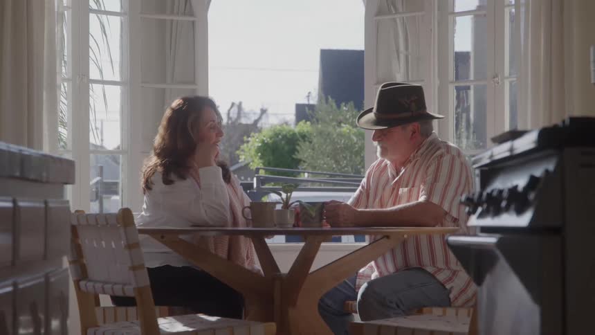 Couple sitting at a table talking in a naturally lit room