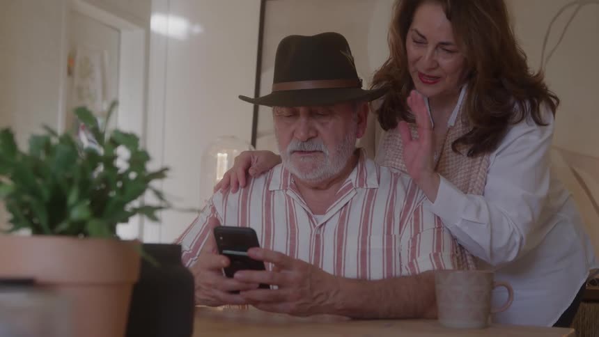 Couple joining a video call on a smartphone in a home setting