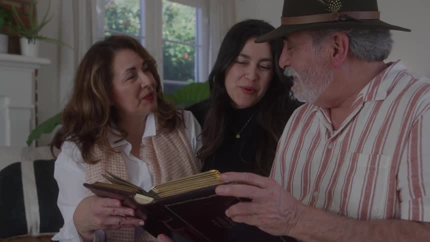 Family gathered together flipping through a book