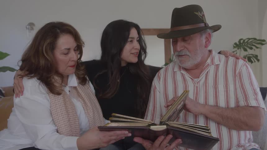 Family gathered together flipping through a memory album
