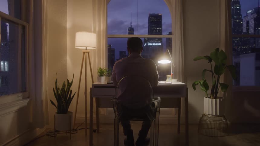 A man sits at his desk at night