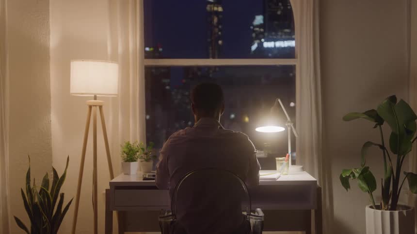 A man sitting at his desk at night