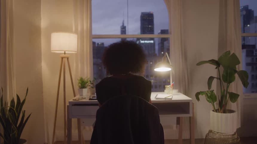 A girl sitting at her desk at night