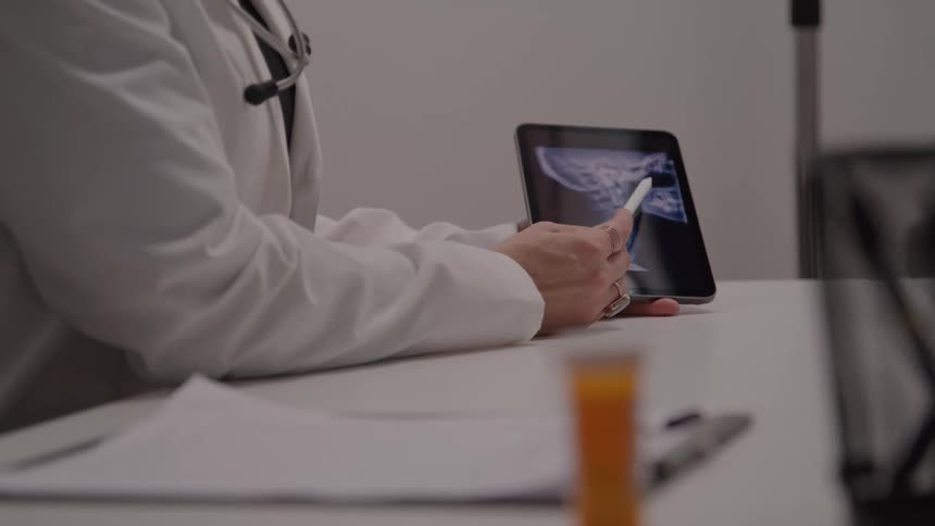 Doctor examines an xray on a tablet on the office desk