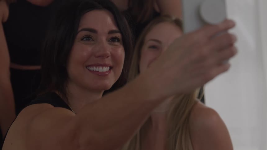 Women smile together while capturing a joyful moment