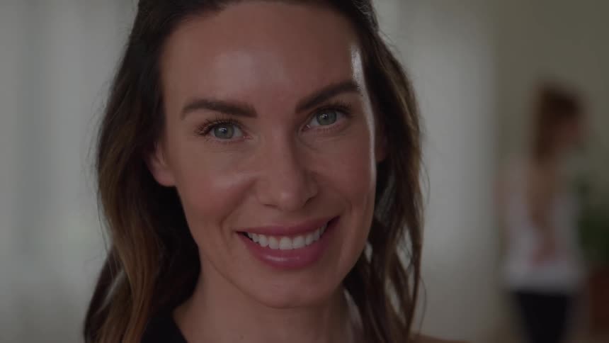 Woman smiles looking directly forward in an indoor setting