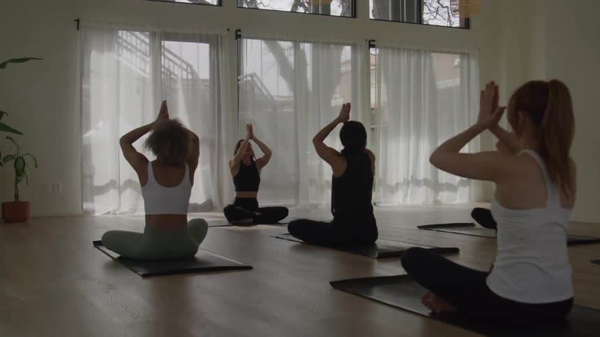 The women are meditating in the gym
