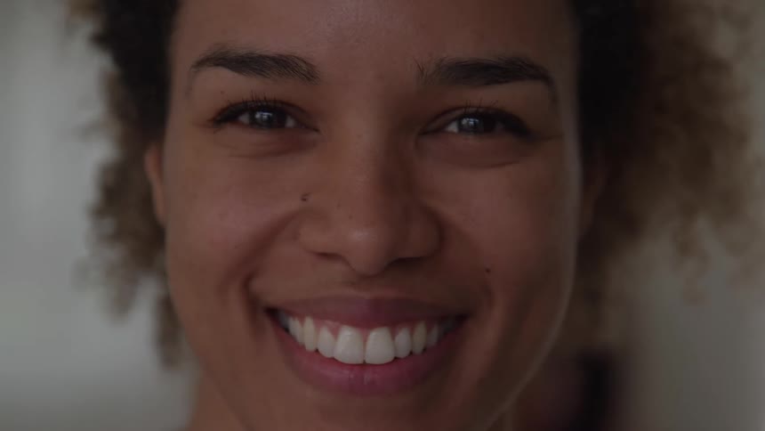 Woman smiles broadly while indoors
