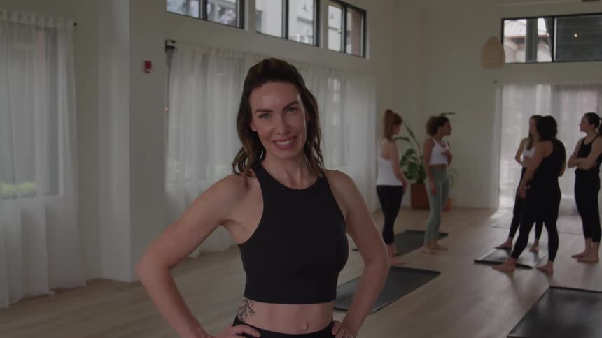 The yoga instructor is posing and smiling