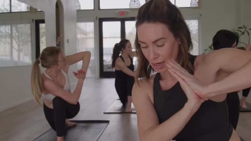 The yoga instructor is speaking to the class