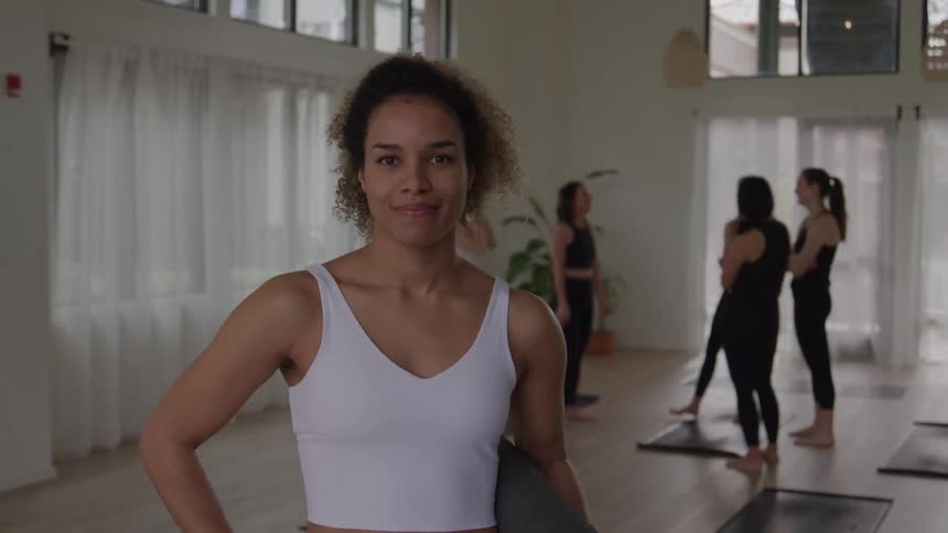 The woman smiles in the yoga studio