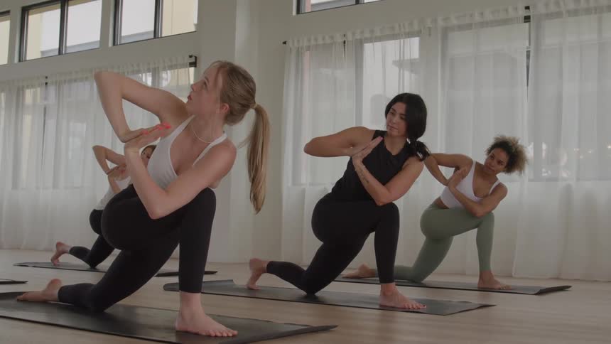 The women are kneeling and doing yoga