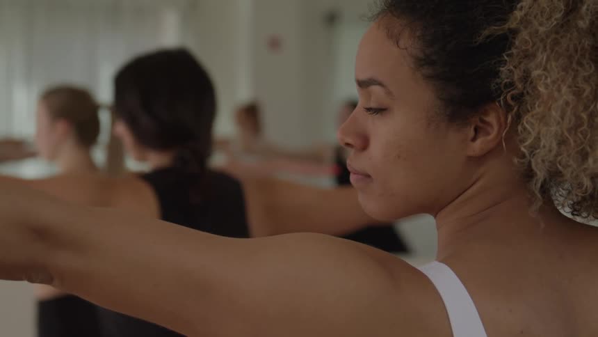 The women doing yoga have their arms stretched out