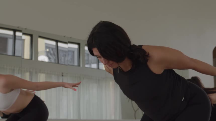 Woman raises her arms above her head during a yoga practice