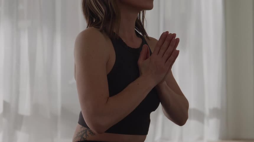 The woman has her hands together meditating