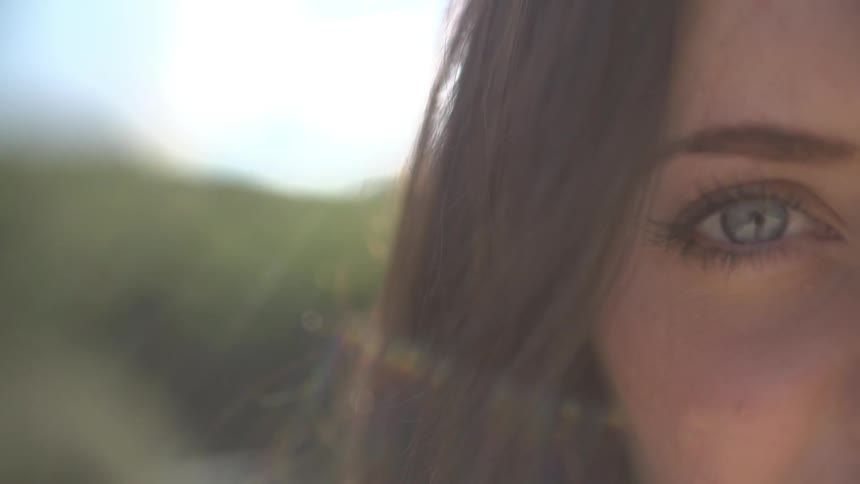 One green eye of young woman staring at the camera