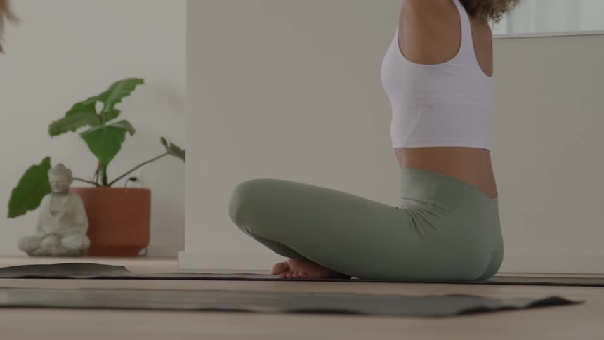 The women sit and stretch their arms out doing yoga