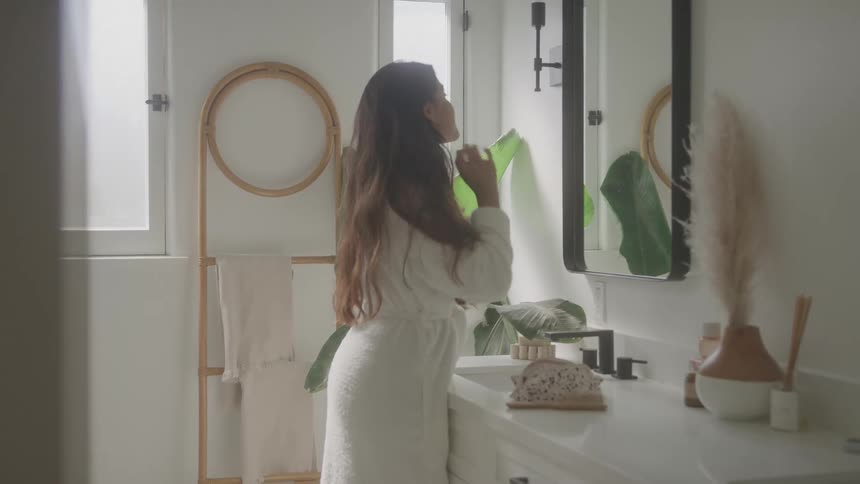The woman brushes her hair with her hands
