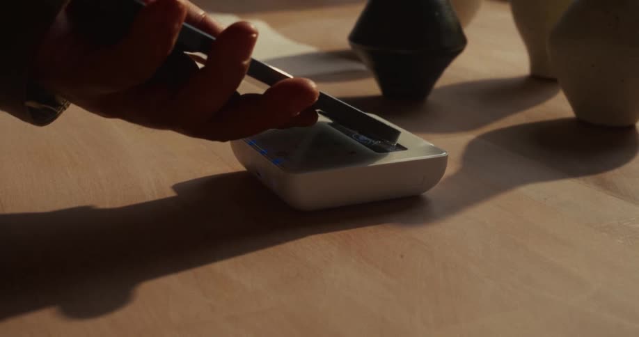 Hand makes a contactless payment on a card reader on the table