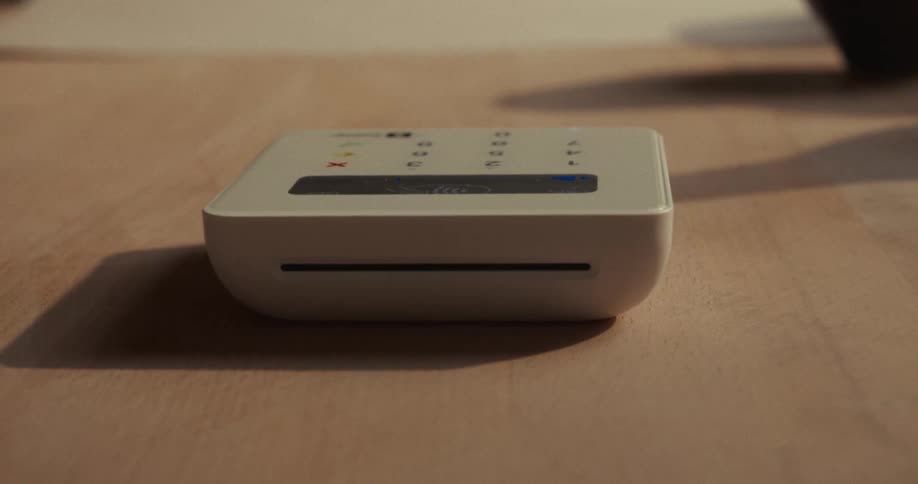 A person holds their phone close to a scanner in order to make a payment