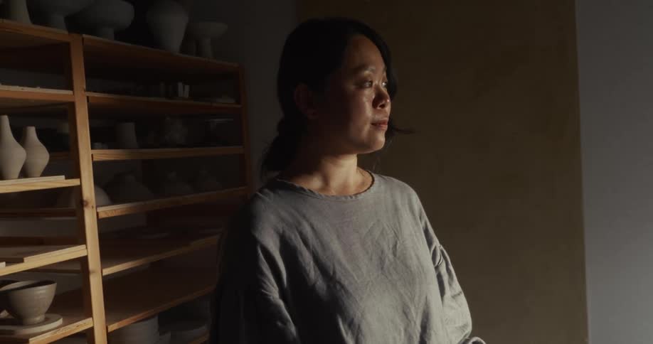 Person observing the pottery studio under soft light