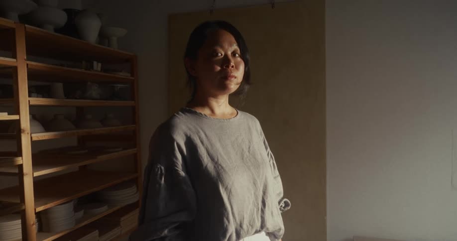 Portrait of a young asian woman standing in a pottery room during daytime