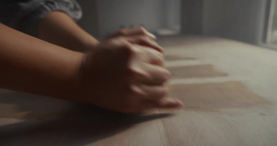 Hands pressing and shaping clay on the table