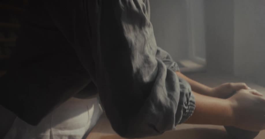 The woman is rolling the clay on the table