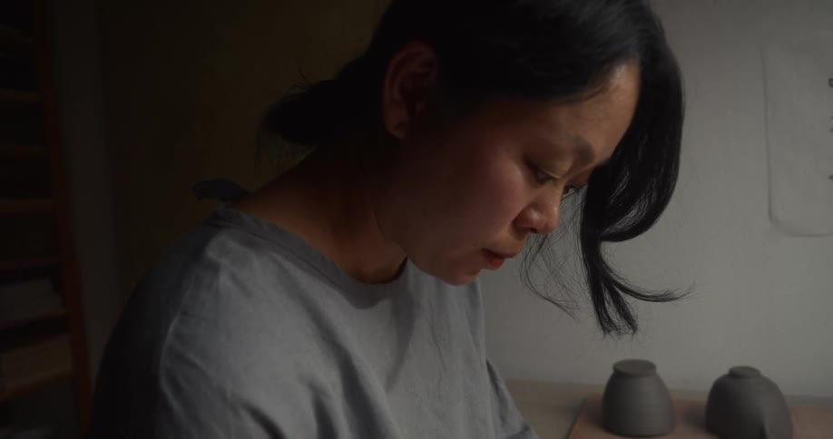 Woman works with focus in a pottery studio