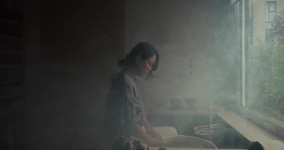Person working with ceramics in a studio lit by natural light