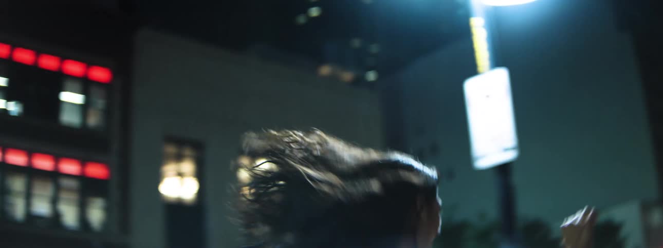 Woman running joyfully through a brightly lit street at night