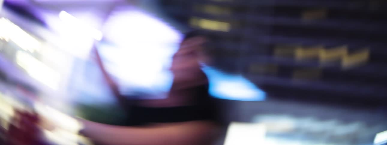Woman dancing under vibrant lights in a nighttime urban setting