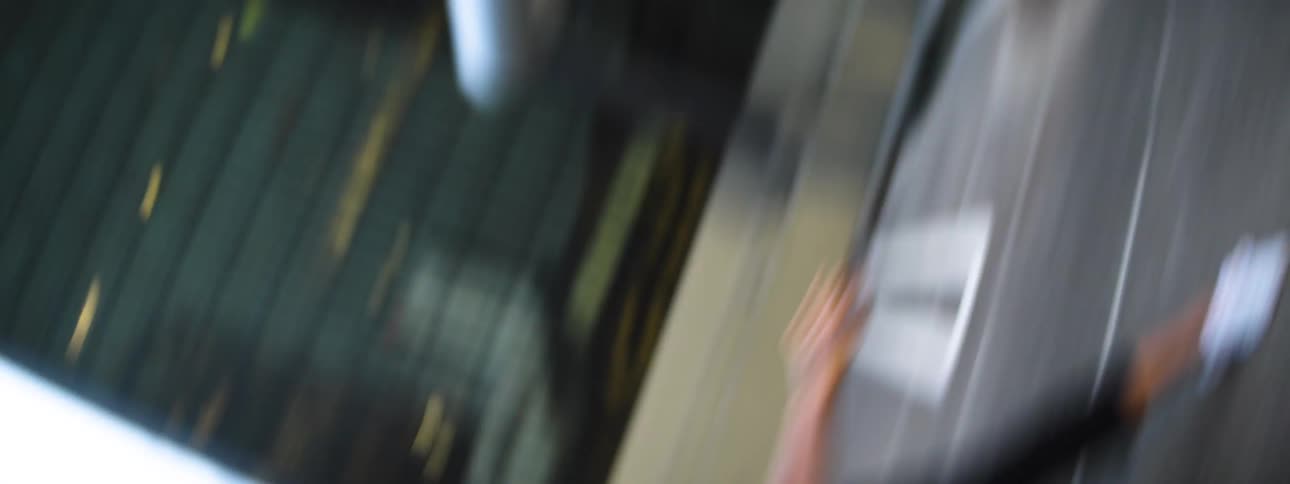 The camera moves erratically around a female dancer on a parking structure