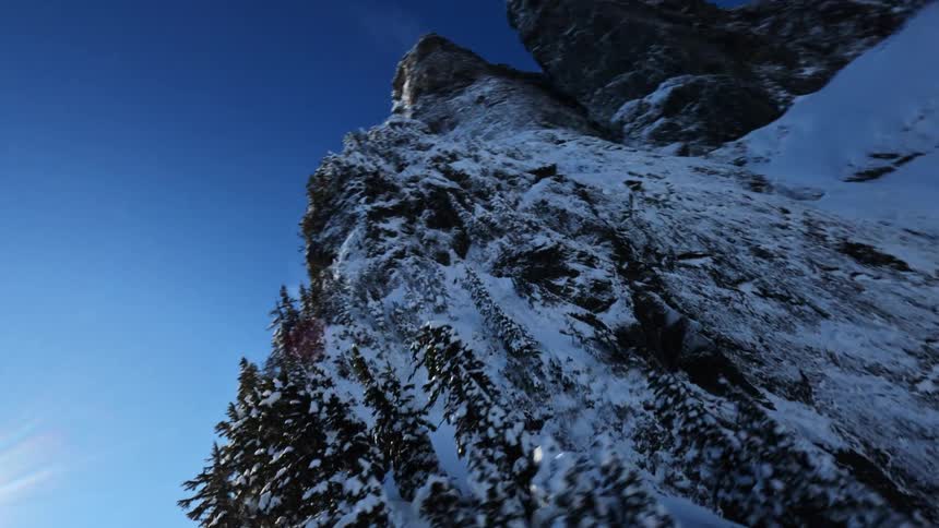 Snowcovered rocky peak under a bright blue sky