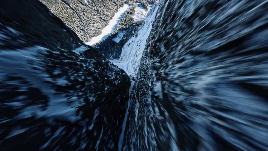 The arctic mountain with its rough terrain is blanketed in snow and illuminated by the midday sun
