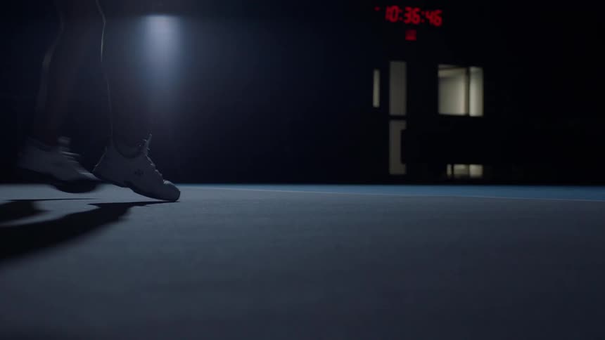 Close up of a female tennis players legs as she practices in an indoor court at night