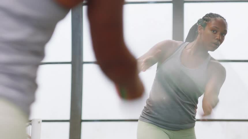 Close up of a young black female athlete practising tennis racket swings in an indoor court