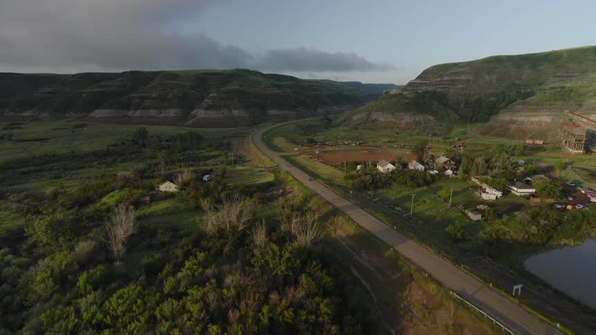 Wide shot of motorcycle riding towards large hills
