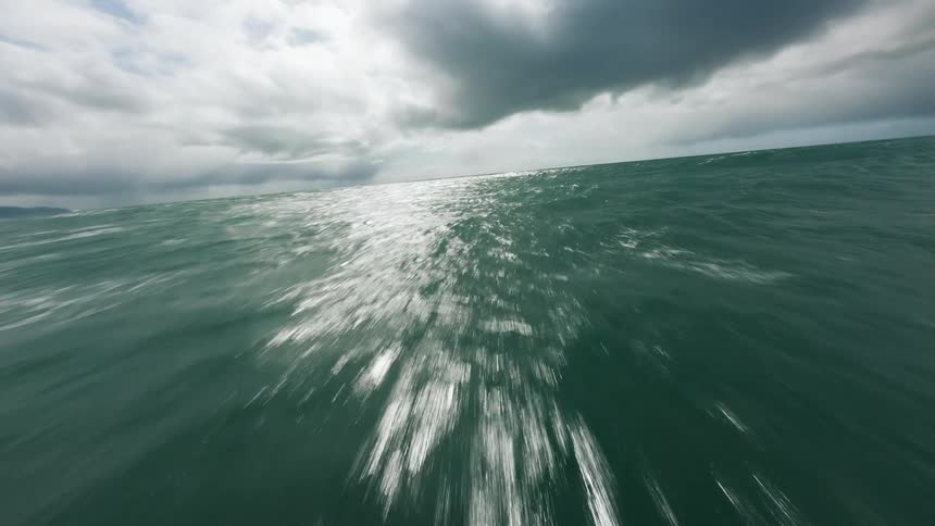 Flying over the ocean near the coast at great speed