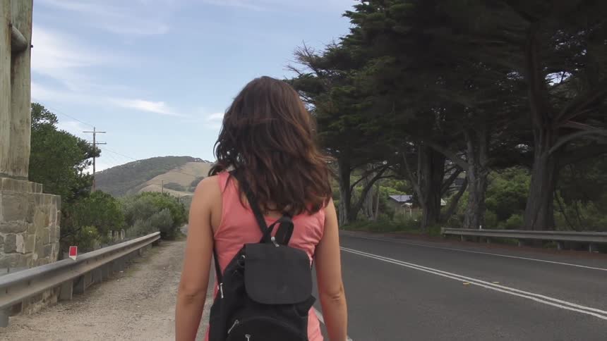 A woman walks down a road