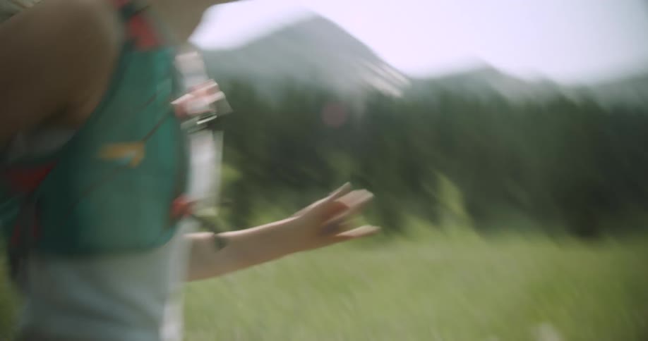 Close up of a young woman running on a field outdoors during daytime