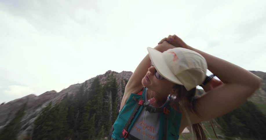 The woman is stretching by the mountains