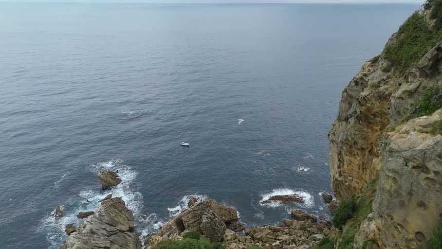 Flying over a large coastal area with tall cliffs